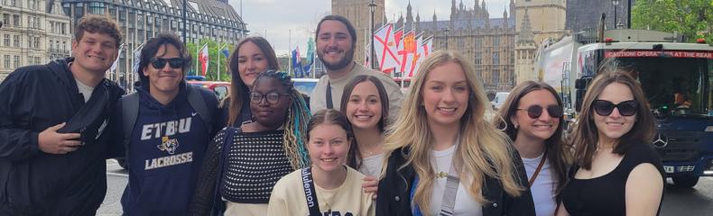 A group of people standing outside together in front of Big Ben in London