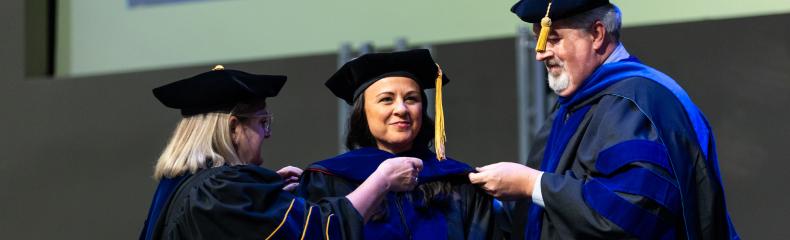 A group of people standing on a stage in academic regalia