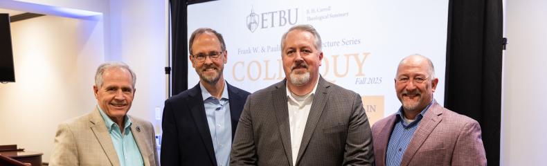 A group of men standing in formal attire together inside