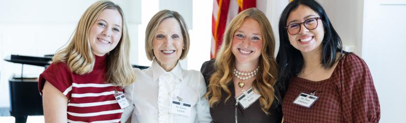 A group of women stood smiling together indoors