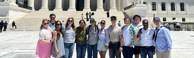 A group of students standing in front of the Supreme Court.